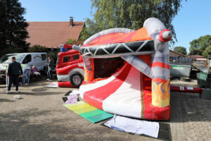 Ein großes aufblasbares Hüpfburg mit Zelt und Lkw, das Freude und Abenteuer für Kinder verspricht.