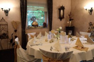 Ein eleganter Tisch, bedeckt mit weißen Tüchern, strahlt zeitlose Raffinesse und stilvolle Einfachheit aus.