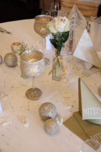 Ein eleganter Tisch mit goldenen und silbernen Dekorationen sowie kunstvollen Platzkarten, der Luxus und Stil ausstrahlt.