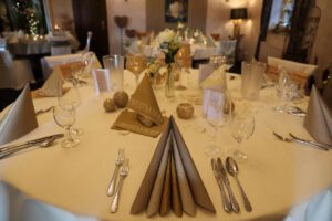 Elegant gedeckter Hochzeitstisch mit stilvollen Servietten und liebevoll arrangierten Platzdeckchen.