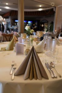 Ein eleganter Tisch, liebevoll gedeckt mit feinen Servietten und glänzendem Besteck, strahlt luxuriösen Charme aus.