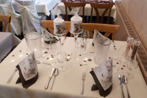 Ein eleganter Tisch mit einem weißen Tuch, das eine Atmosphäre von Raffinesse und Stil ausstrahlt.