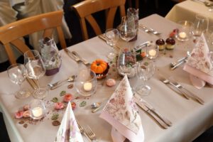 Elegante Tischdekoration mit weißer Tischdecke und zarten rosa Servietten, die eine luxuriöse Atmosphäre schafft.