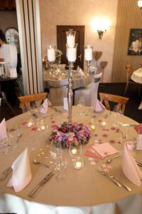 Ein eleganter Hochzeitstisch, geschmückt mit zarten rosa und weißen Blumen, strahlt festliche Romantik aus.