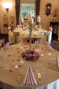 Ein eleganter Hochzeitstisch, geschmückt mit zarten rosa und weißen Blumen, strahlt festliche Romantik aus.