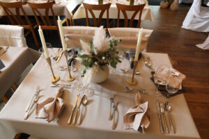 Ein elegant gedeckter Tisch für ein festliches Abendessen, umgeben von stilvollen Dekorationen und Kerzenlicht.