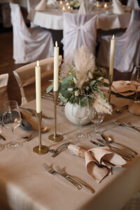 Ein elegant gedeckter Tisch mit Kerzen und feiner Tischdecke, der eine romantische Atmosphäre schafft.