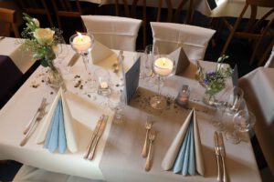 Ein eleganter Tisch mit einem weißen Tuch, das eine Atmosphäre von Raffinesse und Stil ausstrahlt.