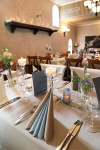 Elegante Tischdekoration mit silbernem Besteck und sanft flackernden Kerzen für eine luxuriöse Atmosphäre.