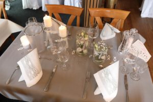 Elegante Tischdekoration mit silbernem Besteck und sanft flackernden Kerzen für eine luxuriöse Atmosphäre.