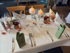 Elegant gedeckter Tisch für ein festliches Dinner, umgeben von stilvollen Accessoires und Kerzenlicht.