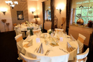 Eleganter Hochzeitsempfangsraum mit stilvollen Tischen und Stühlen, der eine festliche Atmosphäre ausstrahlt.