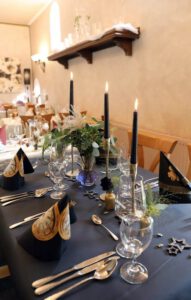 Elegant gedeckter Tisch mit schwarzem Tuch und silbernem Besteck, bereit für ein luxuriöses Dinner-Erlebnis.