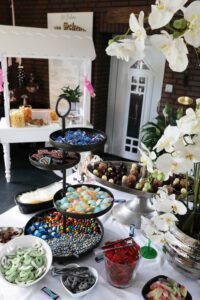 Ein Buffet mit einer Vielzahl von Süßigkeiten in bunten Schalen und Gläsern, die zum Naschen einladen