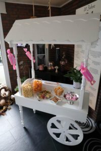 Ein weißer Wagen, gefüllt mit Süßigkeiten und Popcorn, steht bereit für den Genuss.