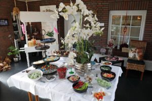 Ein Tisch mit einer Vielzahl von Süßigkeiten und Blumen dekoriert, der eine einladende Atmosphäre schafft.